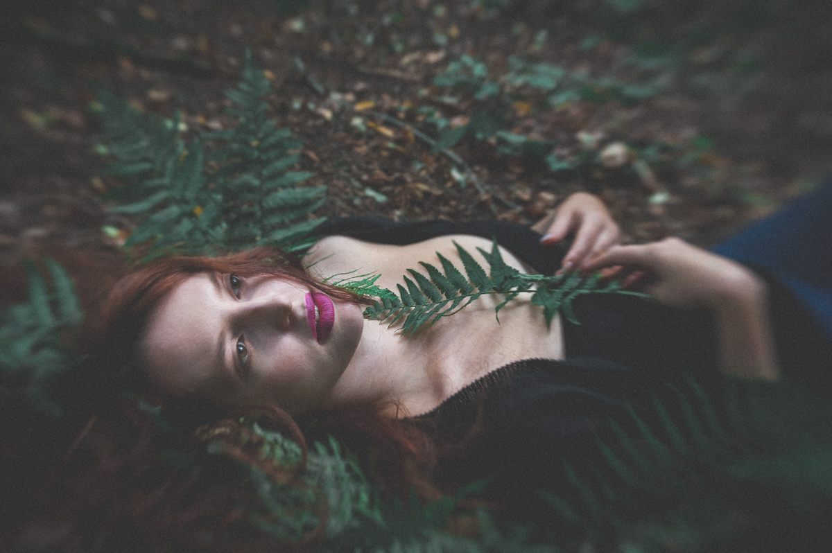 dziewczyna leżąca w lesie na paprociach